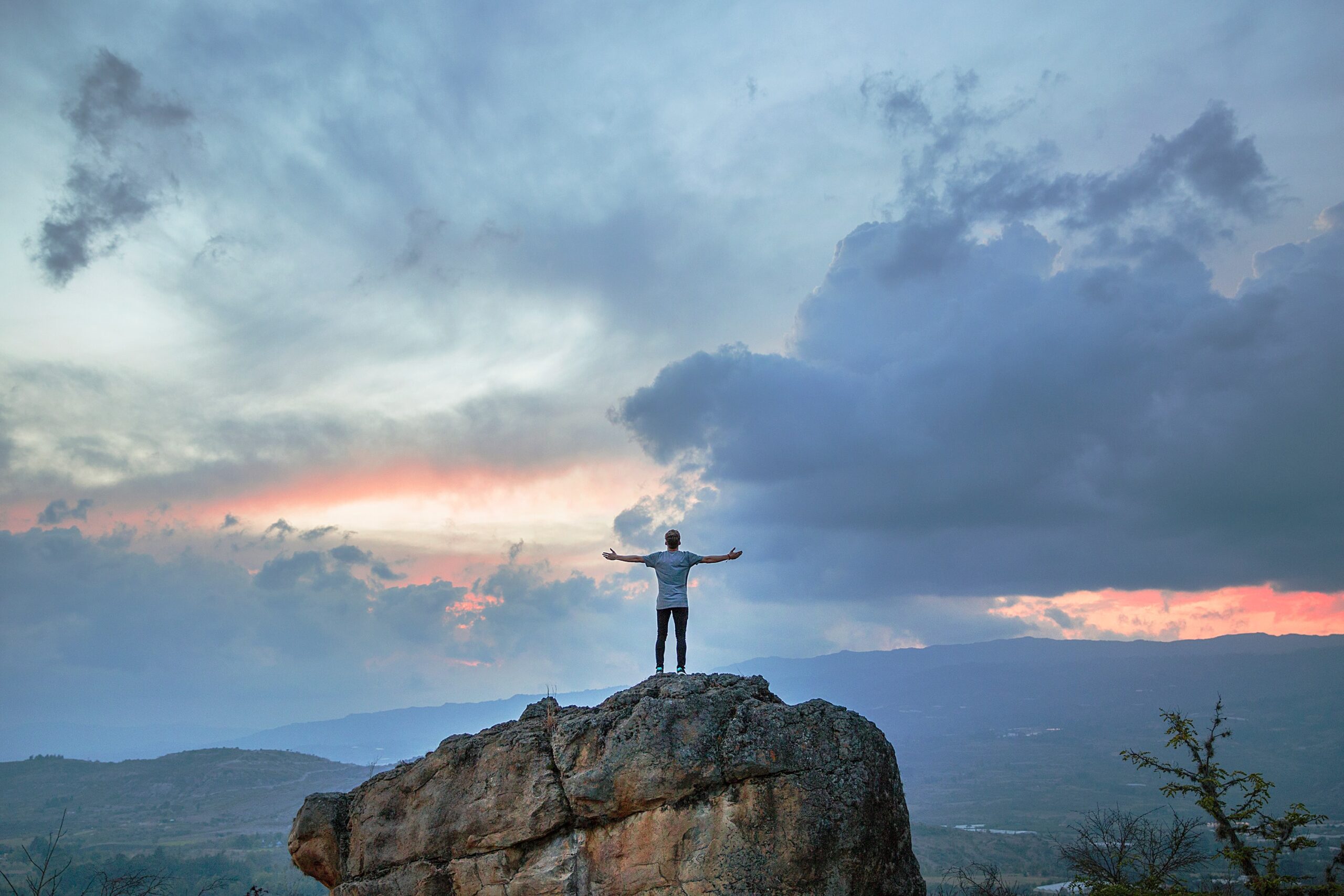 Man on a mountain with arms outstretched symbolizing freedom